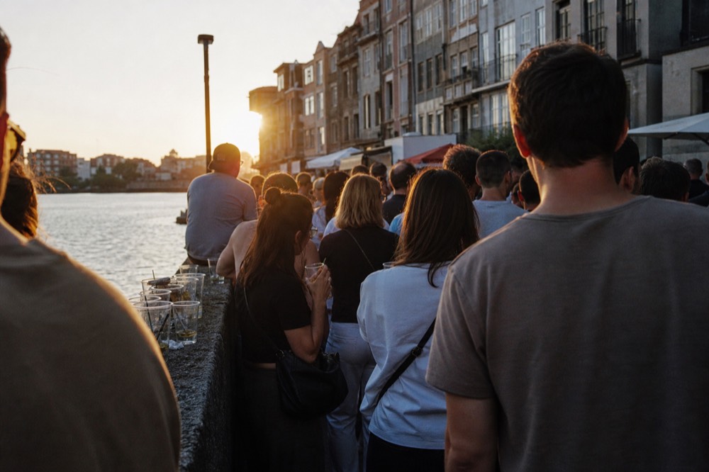A crowded Amsterdam canal quayside on a summer evening, no text, no logos, no people.