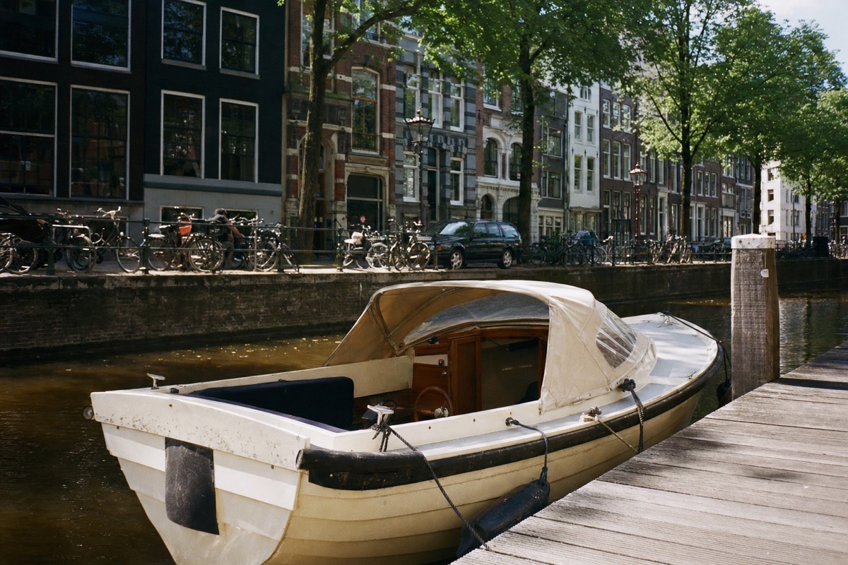 A canal boat moored at a wooden jetty on the Prinsengracht in Amsterdam, no text, no logos, no people.