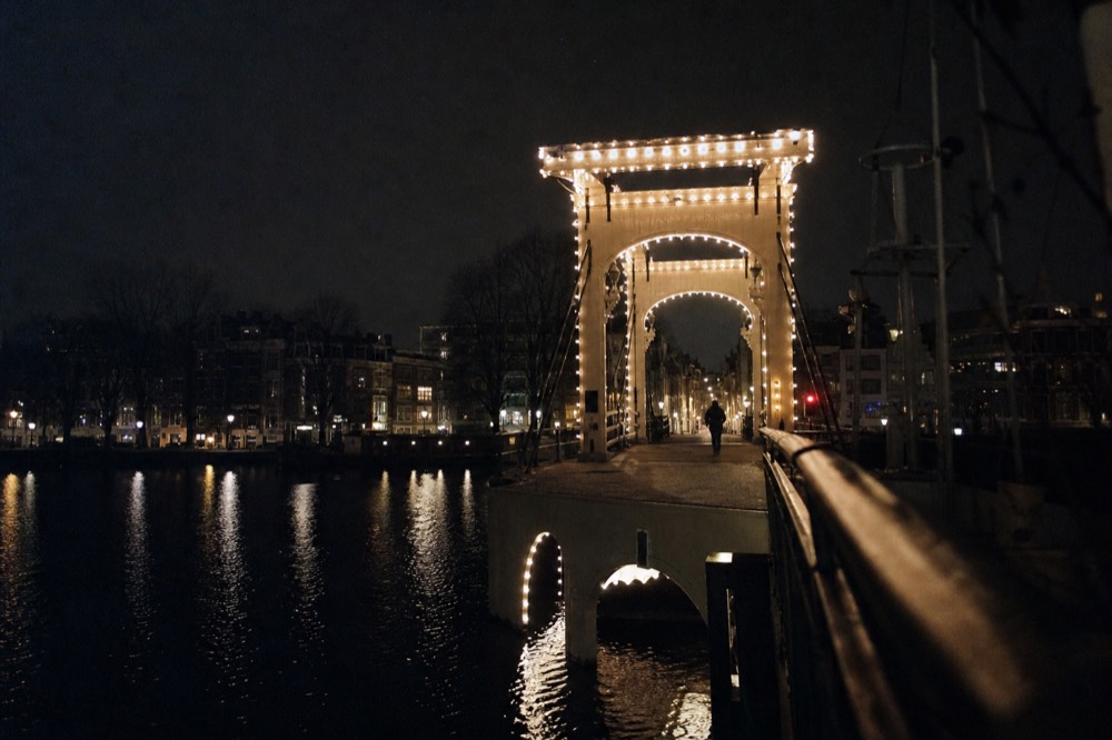 Night view of the Magere Brug bridge lit over the Amstel river, no text, no logos, no people