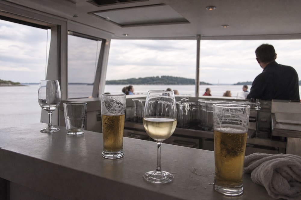 Beer and wine glasses lined on a boat bar counter, no text, no logos, no people.