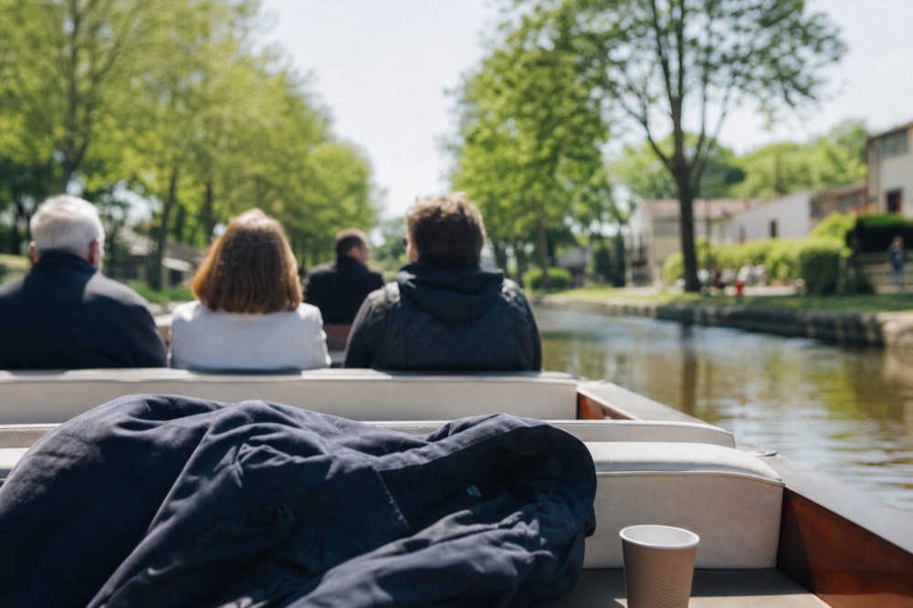 A small group seated in an open electric boat on a calm canal, no text, no logos, no people.