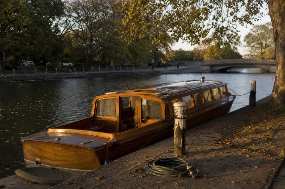 A wooden classic saloon boat moored at a canal jetty in Amsterdam, no text, no logos, no people