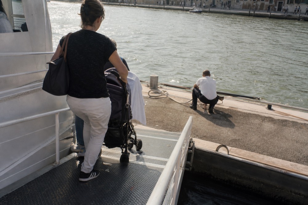 Passengers boarding a canal cruise boat at a central Amsterdam quay, no text, no logos, no people